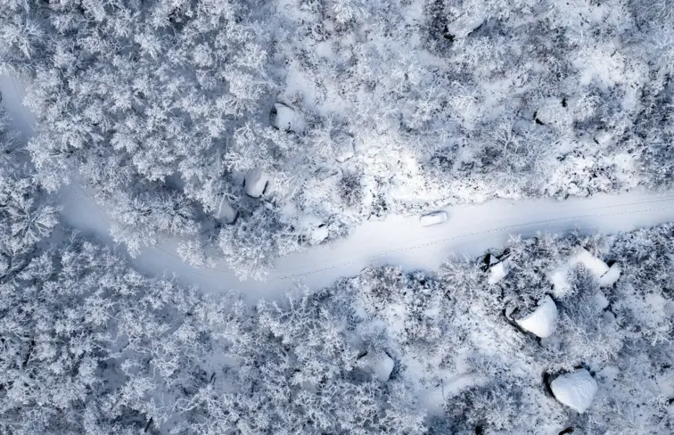 Imagem aérea da aldeia coberta de neve.